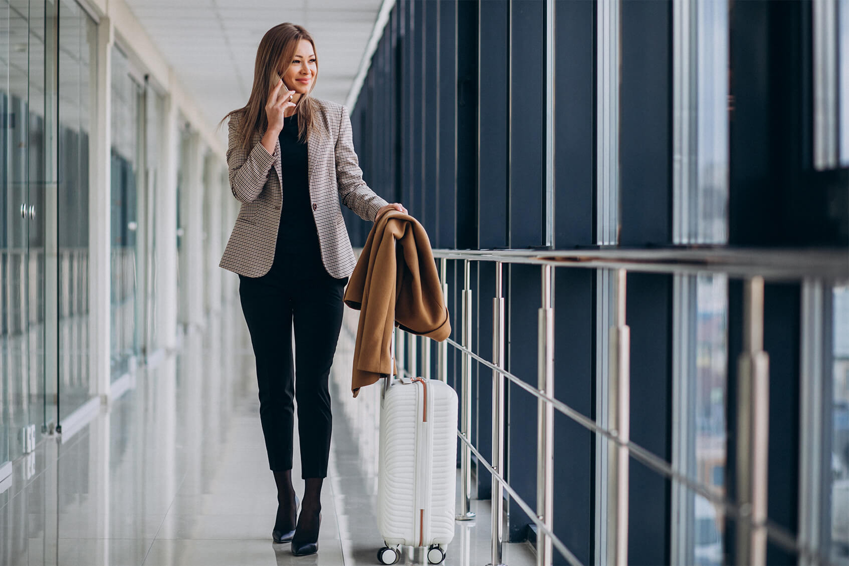 business-woman-terminal-with-travel-bag-talking-phone