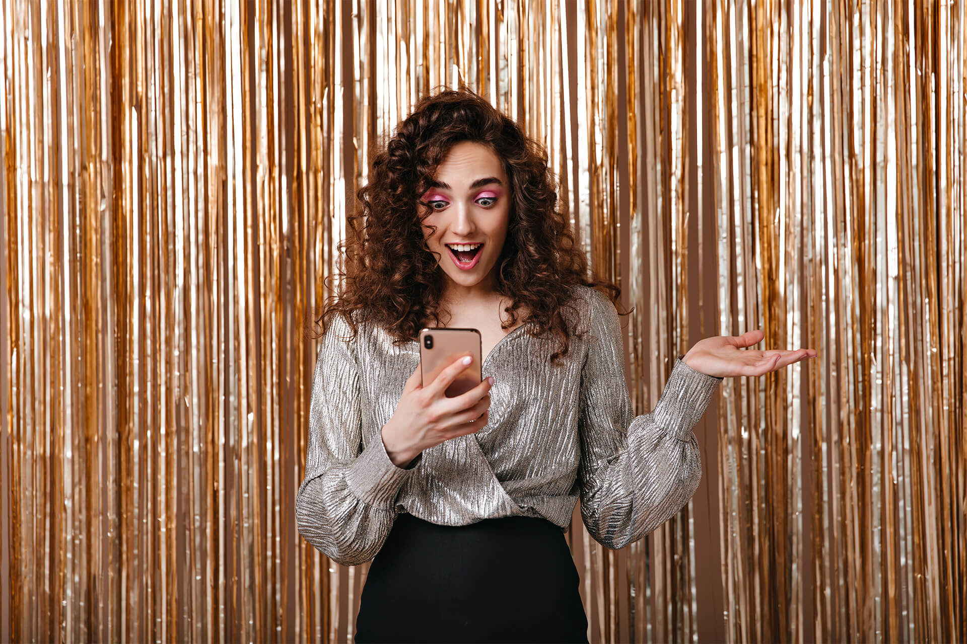 woman-reads-message-phone-posing-surprised-golden-background